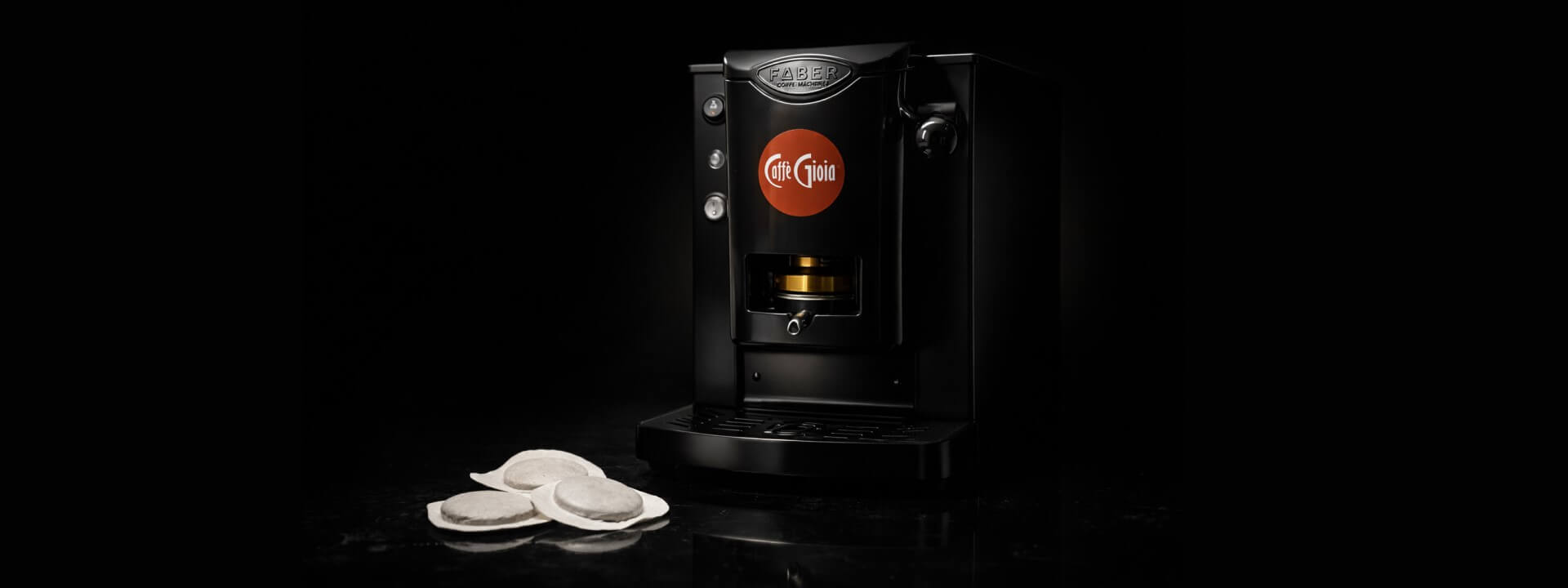 Prémium fekete Caffè Gioia kávégép E.S.E. pod párnákkal, sötét stúdió környezetben