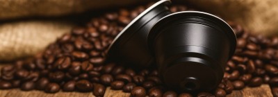 Dolce Gusto kompatibilis kávékapszulák pörkölt kávészemekkel, rusztikus fa felületen – Caffè Gioia kapszulák